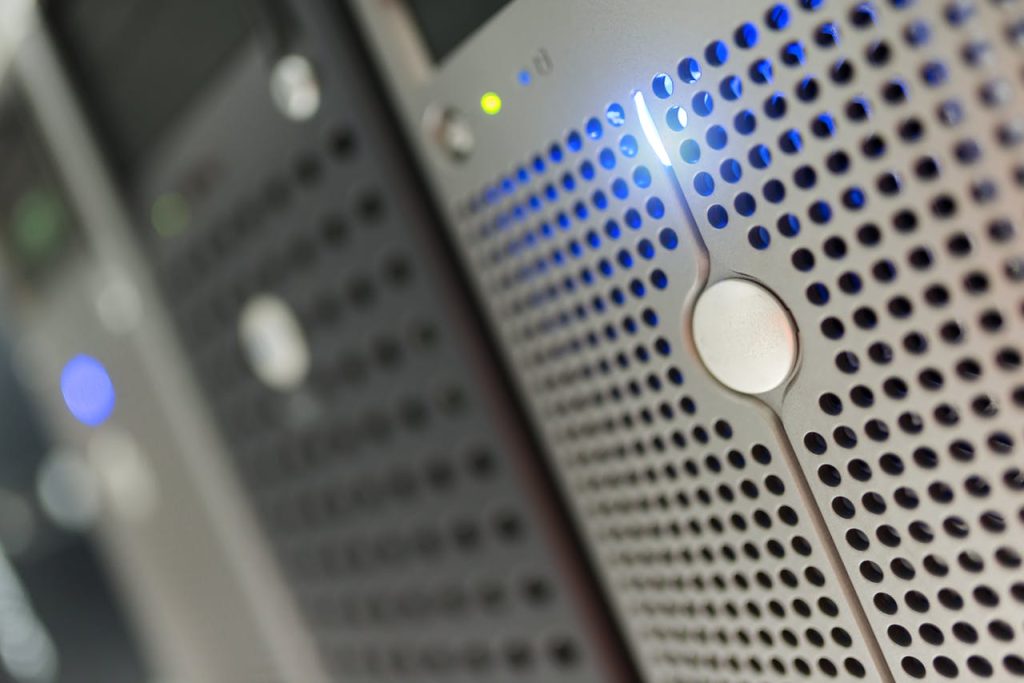 Services Focused detail of a modern server rack with blue LED indicators in a data center.
