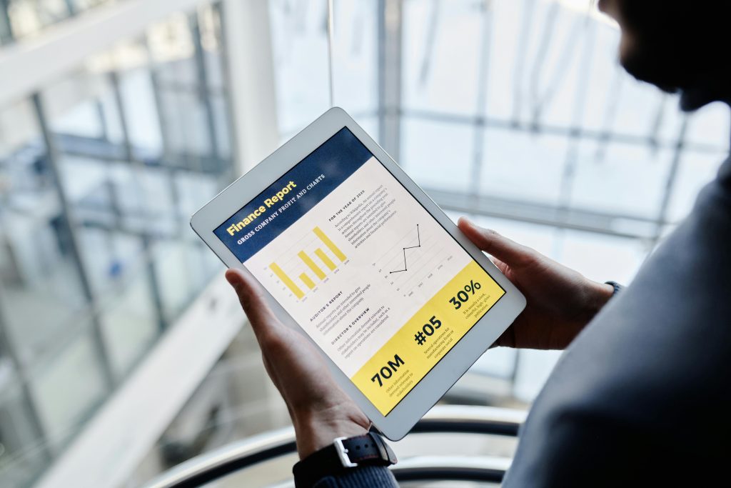 Services Businessman reviewing financial statistics on a tablet indoors.